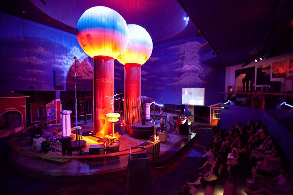 A presenter at the Boston Museum of Science hosts an educational program called Theater of Electricity which uses Tesla coils and the world's largest air-insulated Van de Graaff generator to demonstrate the power of electricity