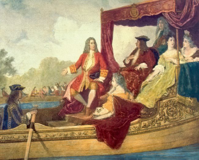 Painting of George Frideric Handel (left, with right arm extended) with King George I of Great Britain, traveling by barge on the Thames River while musicians play in the background. The painting is an artist's rendering of the first performance of Handel's Water Music in 1717.