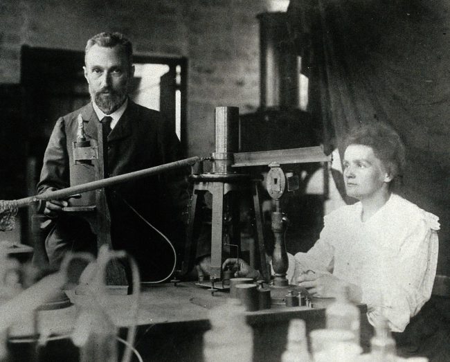 Pierre and Marie Curie in the laboratory, demonstrating the experimental apparatus used to detect the ionsation of air
