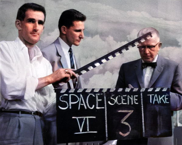 Man with a clapperboard as a scene is ready to be filmed. Production shot from KUHT-TV's Doctors in Space program with Drs. John Rider (center) and Hubertus Strughold (right).